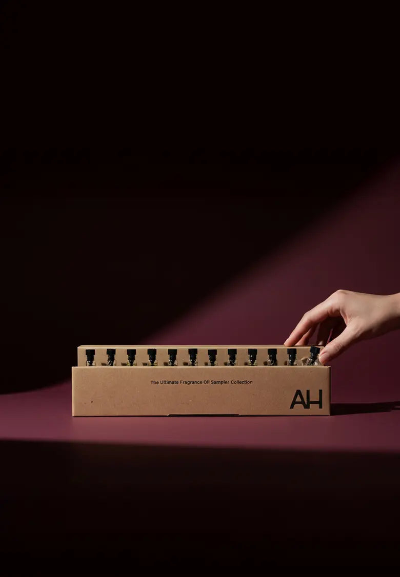 Hand opening a cardboard box with 'AH' branding on a dark background